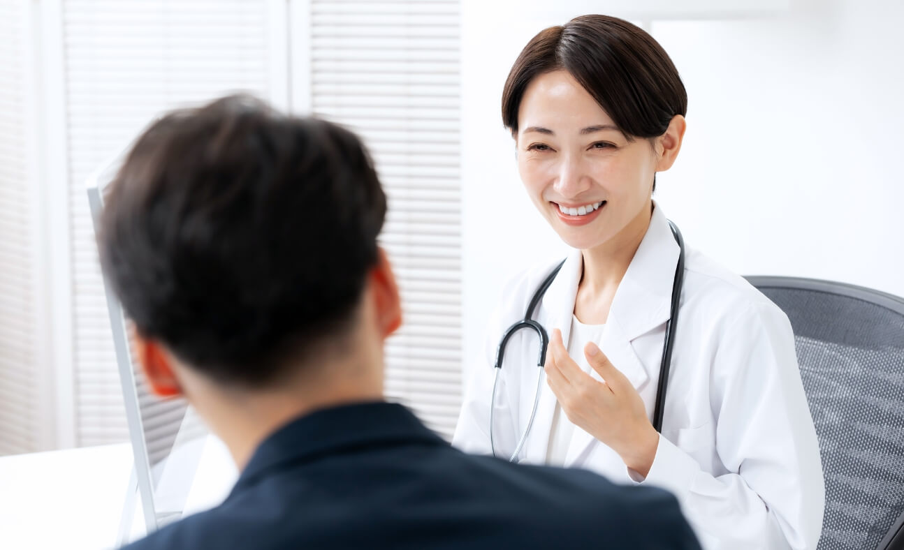 笑顔で話を聞く女医